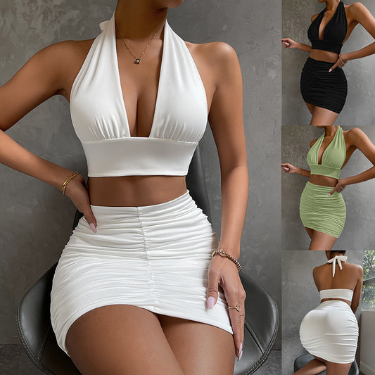 Woman in halter top and pleated skirt set posing in summer light